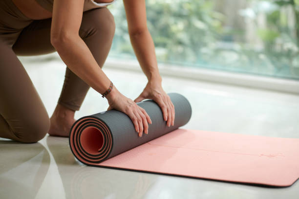 istock Sportswoman Rolling out Yoga Mat 1820101772