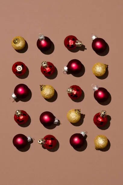Photo of Shiny red and gold Christmas balls on brown background