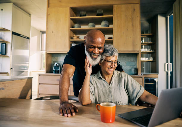 Generation X African-American Couple Enjoying Their Retirement Plans with Laptop at Home