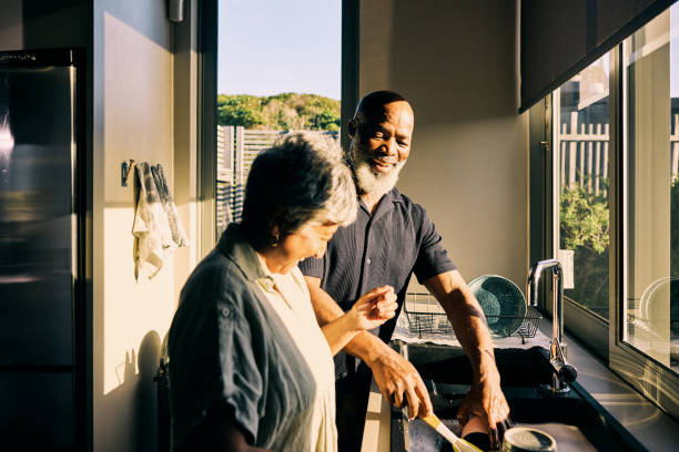 istock Active Retired African-American Couple Sharing a Laugh in Modern Home Kitchen 1820110510