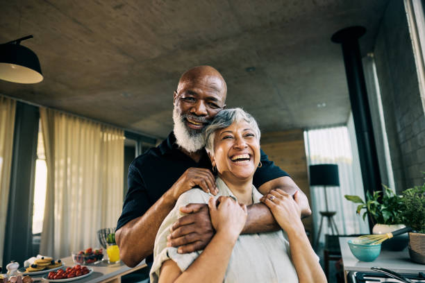 Active Retired African-American Couple Sharing a Laugh in Modern Home Kitchen stock photo