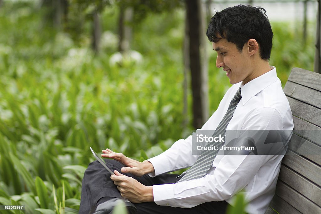 Empresário asiático trabalhando ao ar livre com um comprimido de placebo. - Royalty-free Acessibilidade Foto de stock