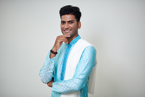 Portrait of cheerful Indian man in blue kurta looking at camera