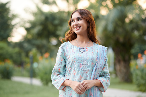 Happy young Indian woman spending time in city park