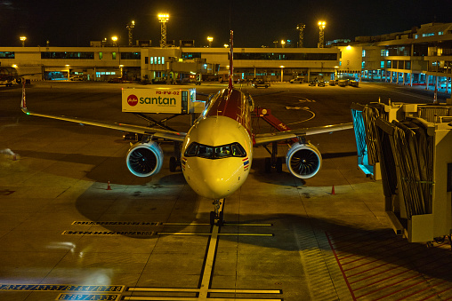 Bangkok, Thailand - December 3, 2022: The plane is about to park on the runway. night flight at Bangkok Thailand