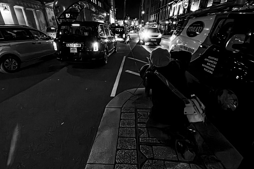 London at night. Long exposure image of Whitehall, London, UK.  There is a photographer taking photographs of traffic along Whitehall.