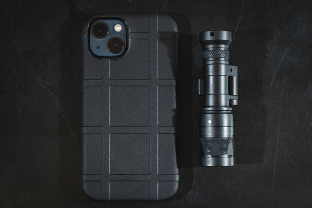 istock A modern phone with two cameras in a rubber protective case and a tactical flashlight. 1820164083