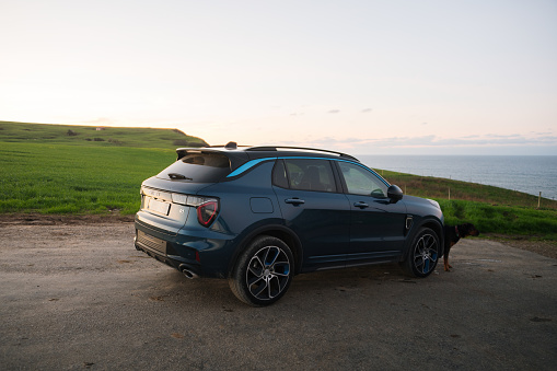 Cobreces, Spain - 23 November 2023: A Lynk & Co 01 electric SUV car in a natural area by the sea at sunset
