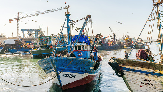 Essaouira, Morocco - 17 September 2022: Fishermen on a fishing boat returning from sail and bringing in the day's catch to port of Essaouira