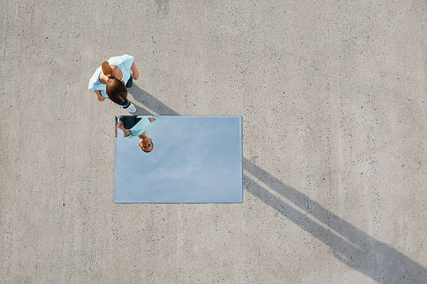 woman standing above mirror and reflection outdoors - abstrakt fotografier bildbanksfoton och bilder