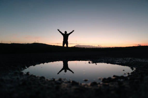 istock Man with arms raised at sunset 1820213418