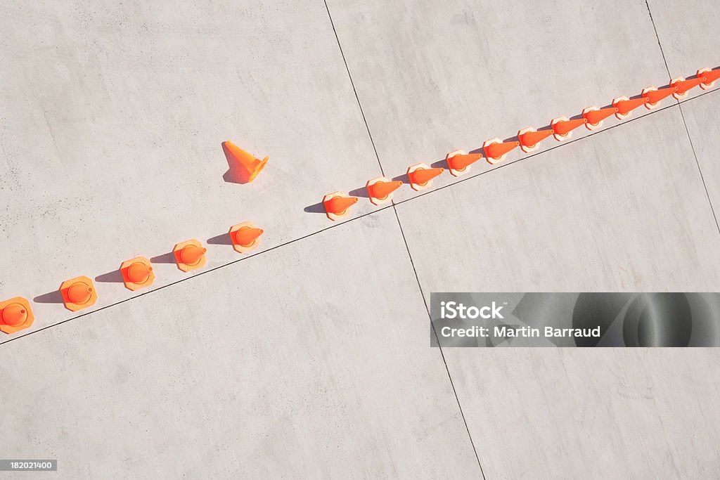Row of traffic cones with one on side  Conformity Stock Photo