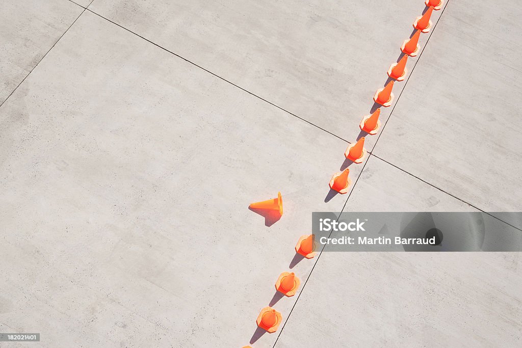 Row of traffic cones with one on side  Risk Stock Photo
