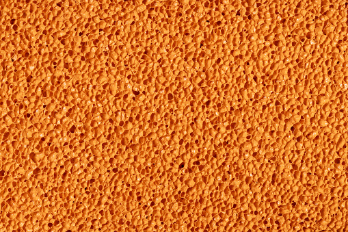 Close up of orange rubber sponge background. This file is cleaned and retouched.