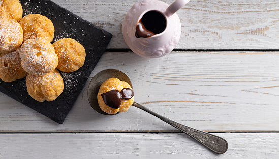 Delicious profiteroles, cream puff filled with fresh cream with chocolate topping.