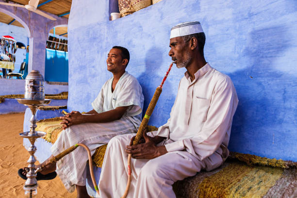 ヌービアン男性喫煙 waterpipe 南部のエジプト - muslim cap ストックフォトと画像