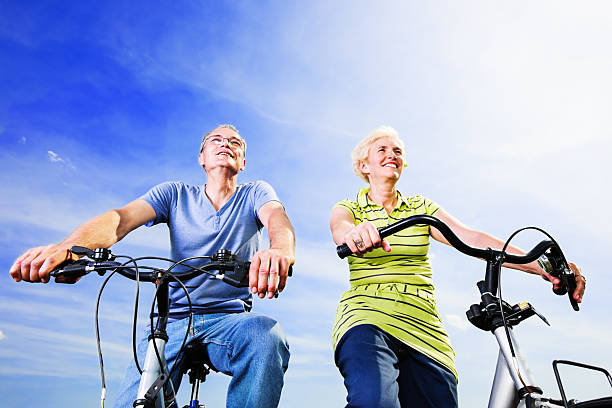 istock Cheerful mature couple riding bicycles in park 182025540