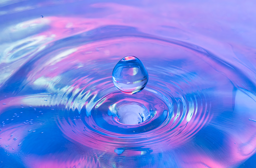 Close up of a water drop impact on a body of water and splash. environment photo of a water droplet splash.