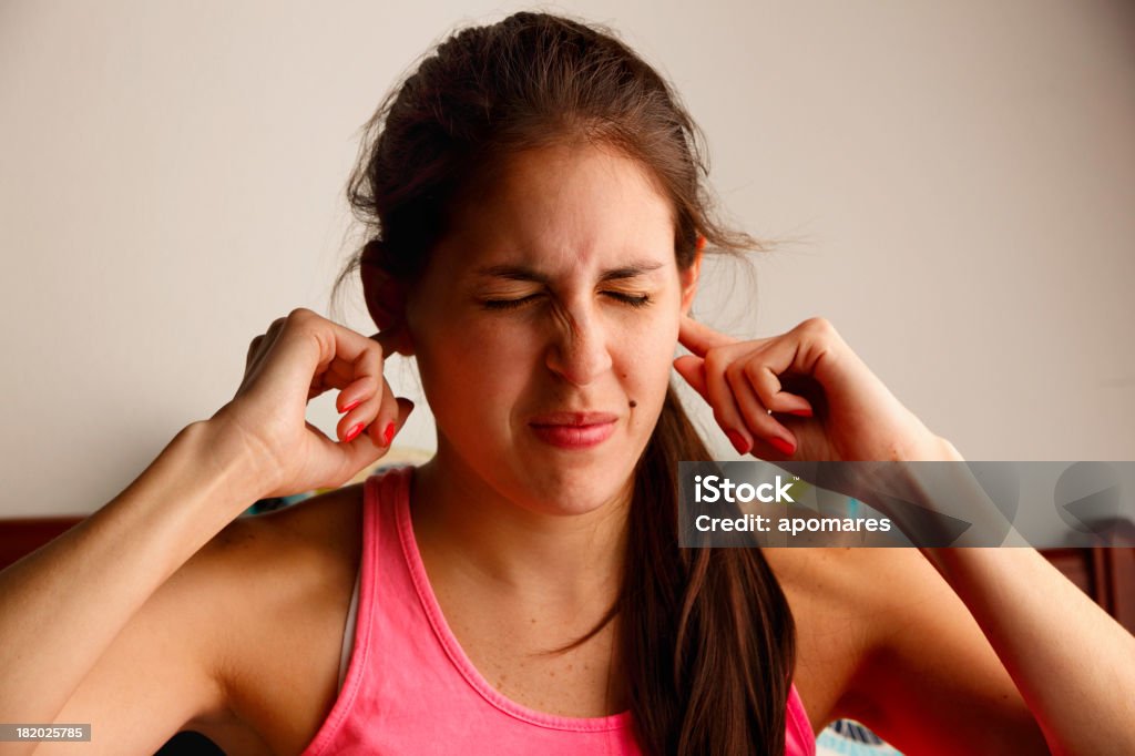 Young woman disturbed by loud noise pollution Tinnitus Stock Photo