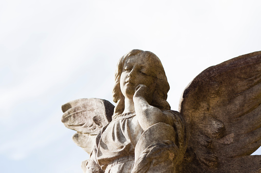 Closeup old statue of angel against sky, full frame horizontal composition with copy space