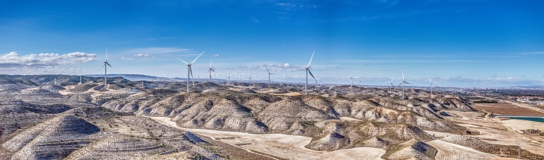 Drone panorama over a wind farm in a hilly desert landscape in Spain during the day