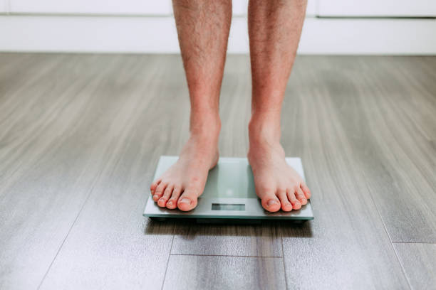 istock Checking his weight on the electronic weighing scale 1820264182