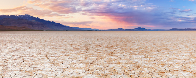 Cracked earth in a dry lakebed in the Alvord desert in southeastern Oregon, USA. A seamlessly stitched panoramic image photographed at sunset.