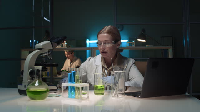 Female Scientist and Assistant Working at Chemistry Lab