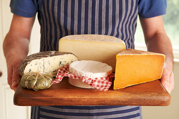 istock Grocer Holding Board With Selection Of Luxury Cheeses 182027033