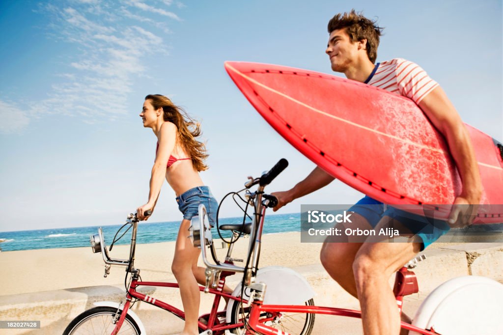 Couple équitation vélos sur la promenade de la plage - Photo de Faire du vélo libre de droits