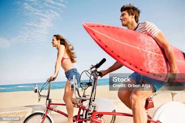 Photo libre de droit de Couple Équitation Vélos Sur La Promenade De La Plage banque d'images et plus d'images libres de droit de Faire du vélo