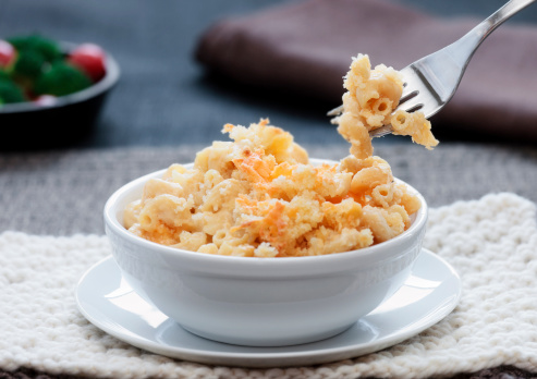 Macaroni and cheese baked in a simple white bowl.