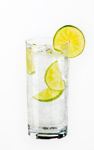 glass of water with ice cubes and slices of lime