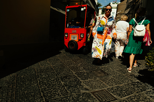 Tourists walking along Via Vittorio Emanuele in the main village of the island of Capri, Bay of Naples, Italy.