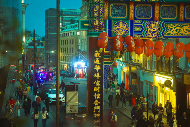 Crowds of people enjoying night in the busy pedestrian streets of Chinatown, London