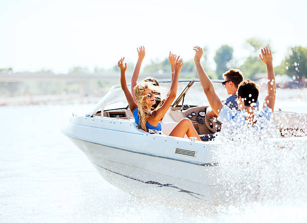 joyeux jeunes équitation dans un hors-bord. - motorboat nautical vessel speedboat lake photos et images de collection