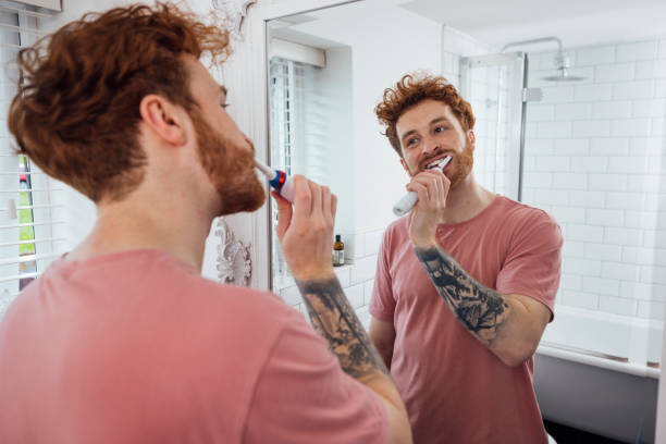 brushing teeth in the mirror - hairstyle crest imagens e fotografias de stock