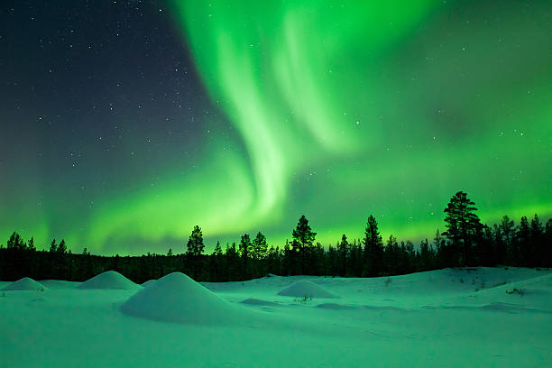 Aurora borealis over snowy landscape winter, Finnish Lapland stock photo