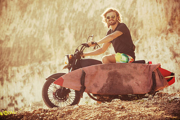 surfer sitting on a bike by beach