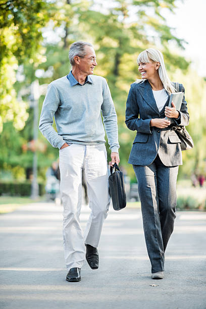 istock Two businesspeople taking a walk in park. 182030654