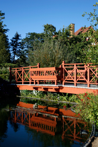 A red bridge in a botanical garden.