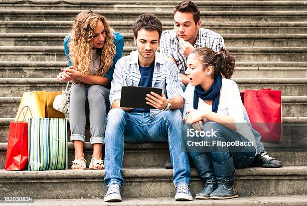 Foto de Quatro Amigos Usando Um Tablet Sentado Na Escada e mais fotos de stock de 20-24 Anos - 20-24 Anos, 25-30 Anos, Adulto