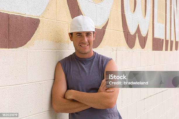 Joven Apoyarse En Pared Foto de stock y más banco de imágenes de De atrás hacia adelante - De atrás hacia adelante, Hombres, Sombrero