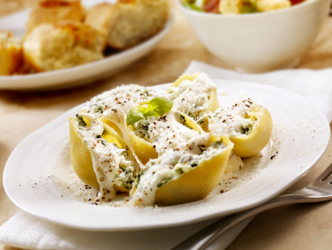 Authentic Italian Stuffed Pasta Shells with Ricotta and Spinach topped with Alfredo Sauce and Parmesan Cheese with Caesar Salad and Garlic Bread -Photographed on Hasselblad H3D2-39mb Camera