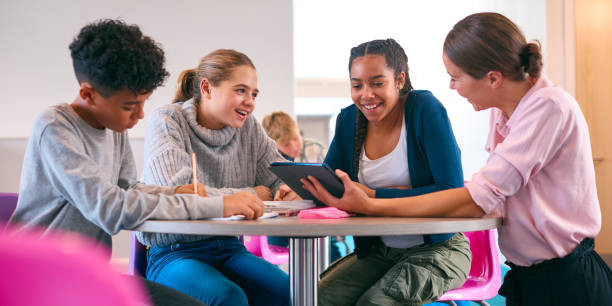 istock Female Secondary Or High School Teacher With Digital Tablet In Study Area With Pupils 1820313787