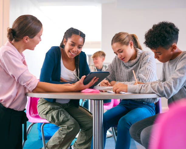 istock Female Secondary Or High School Teacher With Digital Tablet In Study Area With Pupils 1820313788