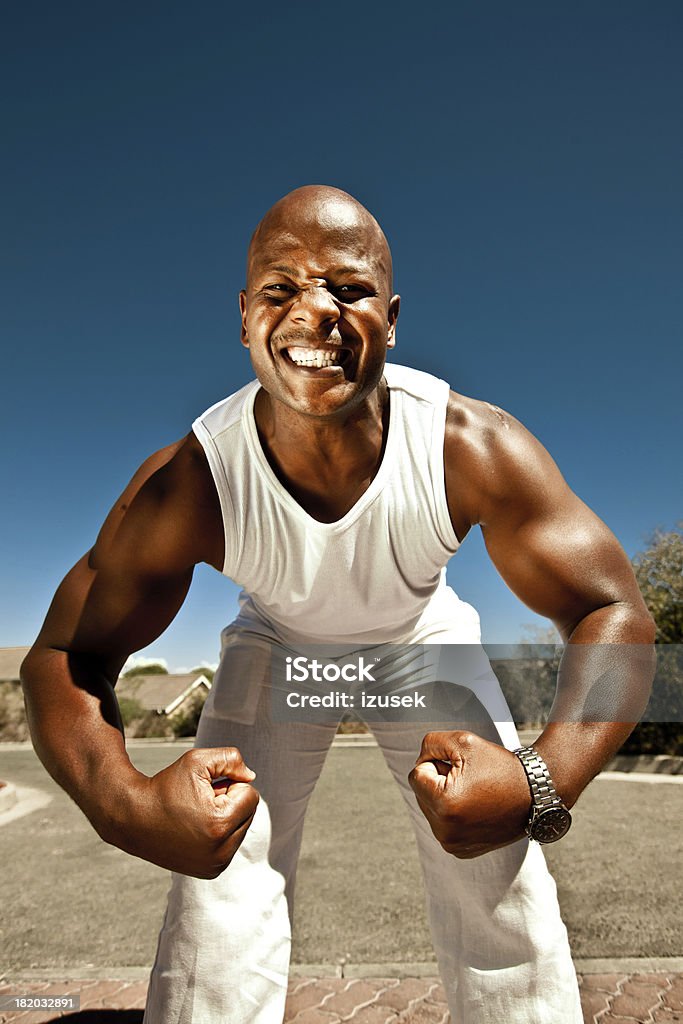 Strong man Muscular man showing his fist and biceps at the camera. Aggression Stock Photo