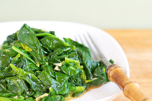istock White Plate of Fresh Sauteed Spinach with Garlic 182032932