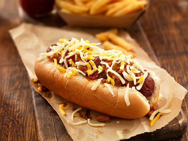 chili-cheese-hotdog - cheese focus on foreground on top of portion stock-fotos und bilder