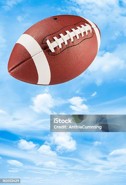 Pelle Marrone Football Americano Midair In Blue Sky - Fotografie stock e altre immagini di Football americano